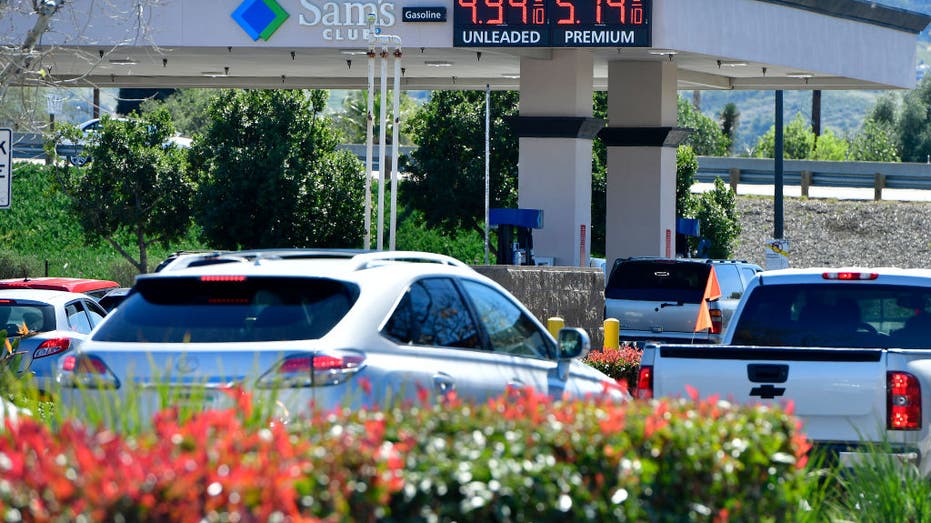 Cars and motorists stand in line at a Sam's Club gas station
