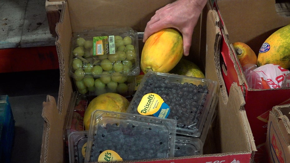 A person putting groceries in a box