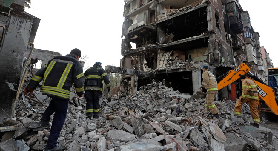 Rescue workers at a damaged residential building in Mariupol