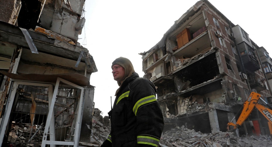 A rescue worker at a damaged residential building in Mariupol