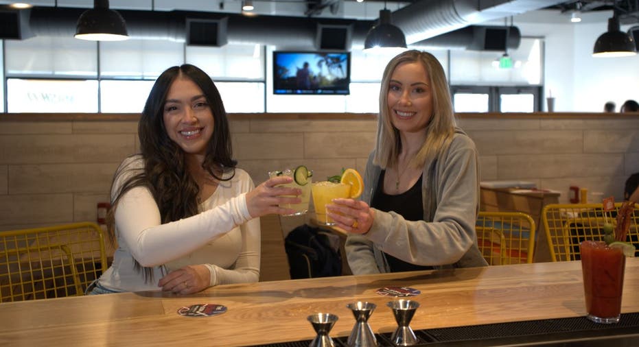 Two women toast at Smashburger's full-service bar