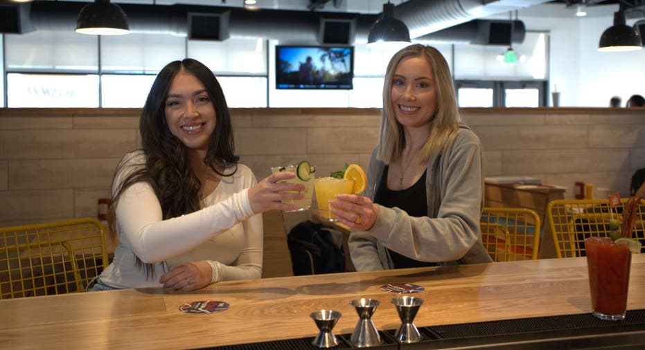 Two women toast at Smashburger's full-service bar