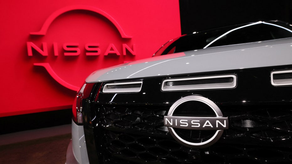 A Nissan vehicle in front of a logo