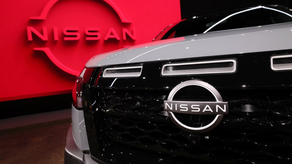 A Nissan vehicle in front of a logo