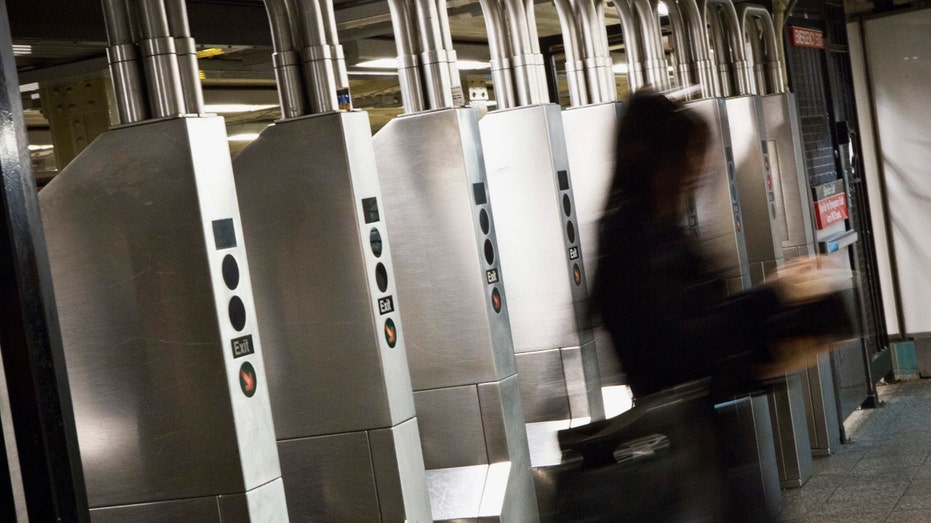 A woman uses an MTA card to enter a New York City subway