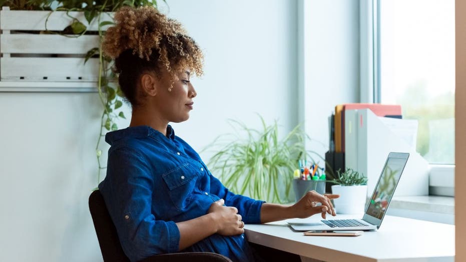 Pregnant worker on laptop