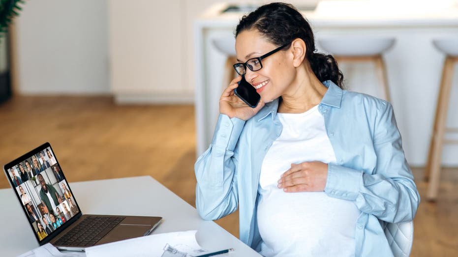 Pregnant worker on laptop and phone