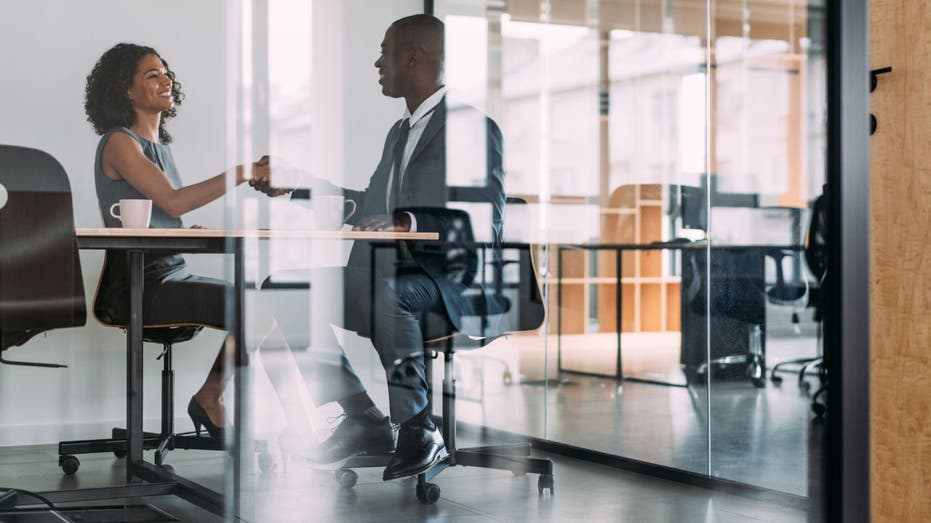 Job interview or meeting happens in glass cubicle