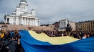 HELSINKI, FINLAND - APRIL 18: A few thousand people gather in central Senaatintori square to show support to Ukraine and to demonstrate against Russia, on April 18, 2022 in Helsinki, Finland. A giant Ukrainian flag is carried down the stairs of Helsinki Cathedral. (Photo by Alessandro Rampazzo/Anadolu Agency via Getty Images)