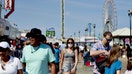 Pedestrians walks along the boardwalk in Seaside Heights, New Jersey, U.S., on Sunday, Aug. 15, 2021. On Monday, New Jersey reported another 1,145 confirmed COVID-19 cases while statewide coronavirus hospitalizations topped 800 for the first time in more than three months. Photographer: Gabby Jones/Bloomberg via Getty Images