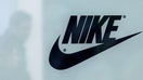 A customer is reflected in a shop window decorated with Nike store logo at the outlet village Belaya Dacha outside Moscow, Russia, April 23, 2016.  - Fox Business News