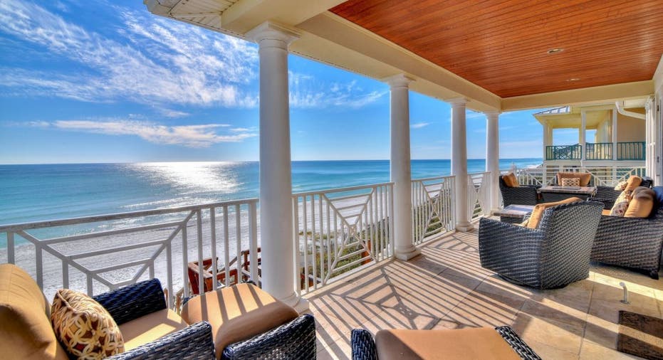 The Gulf Front 30A vacation home on Vrbo is located in Santa Rosa Beach, Florida. This photo shows its ocean-facing covered porch, which has beach furniture.