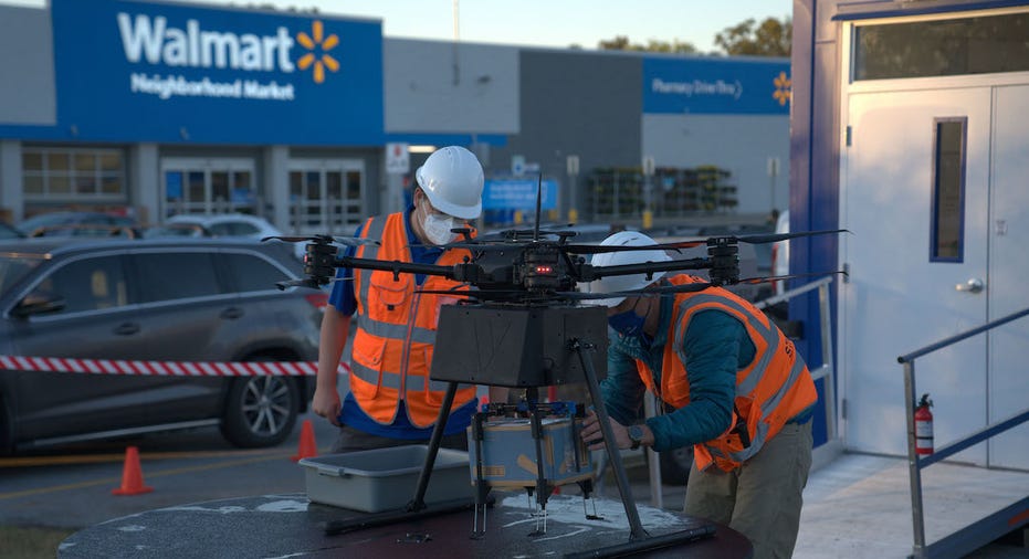 DroneUp employees load a Walmart package into a delivery drone