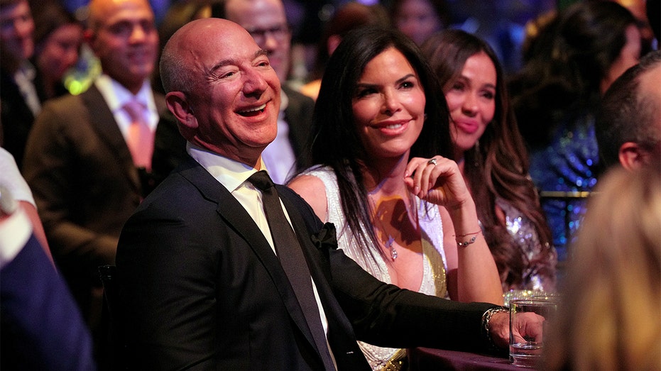 Jeff Bezos in a suit and tie with wife
