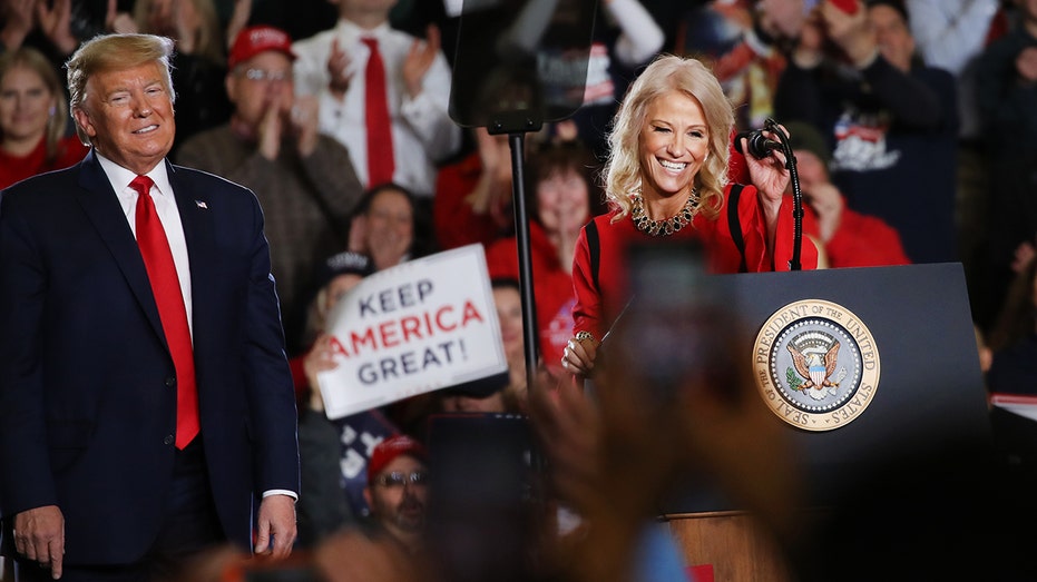 Donald Trump stands next to Kellyanne Conway at a presidential rally