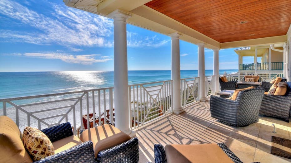 The Gulf Front 30A vacation home on Vrbo is located in Santa Rosa Beach, Florida. This photo shows its ocean-facing covered porch, which has beach furniture.