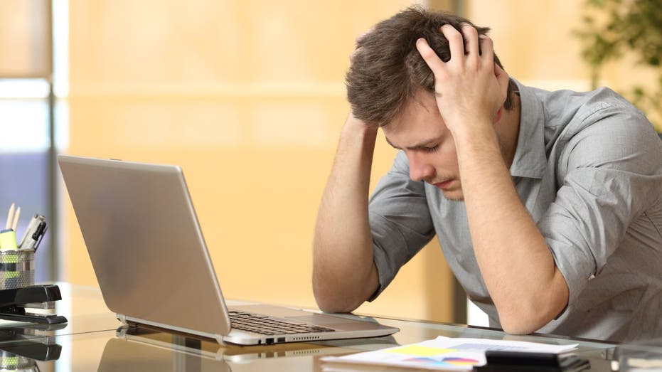 Distressed worker holds head