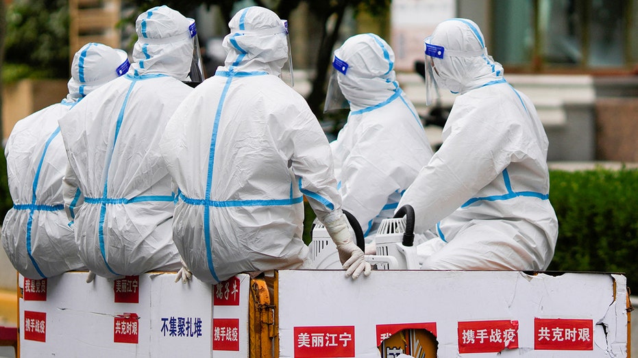 Chinese workers wearing protective suits during COVID-19 Pandemic