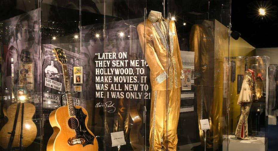 A gold suit and guitar shown in display cases
