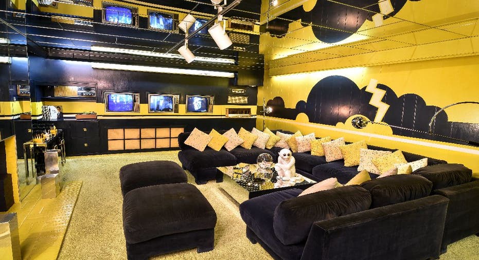 A yellow and black room with three TVs installed into the walls