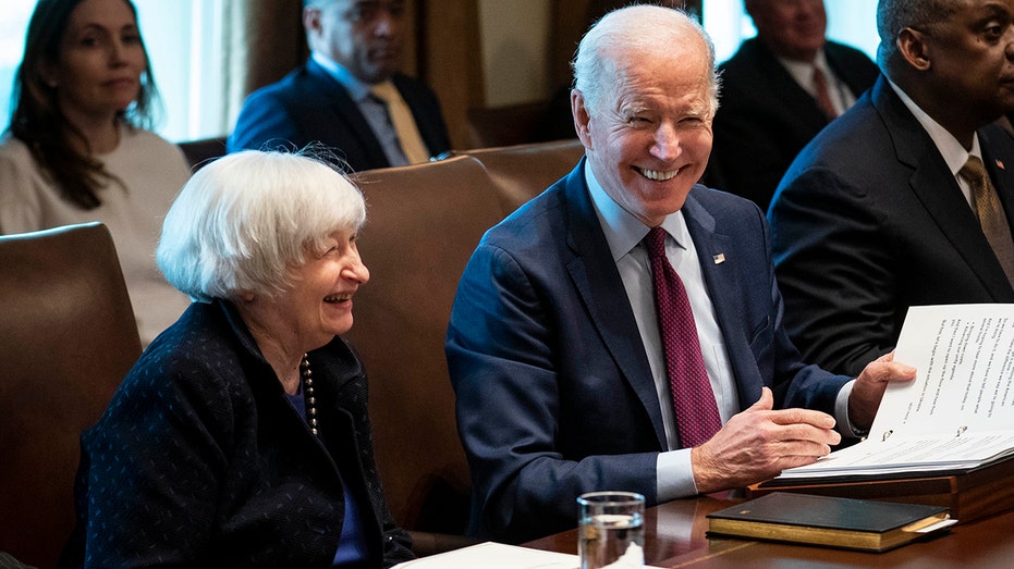 Janet Yellen sits next to President Biden at a cabinet meeting.