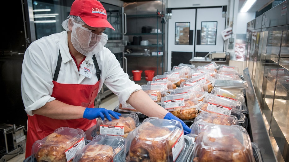 Worker packaging Costco rotisserie chicken