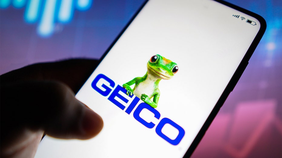 The GEICO logo is seen on a smartphone