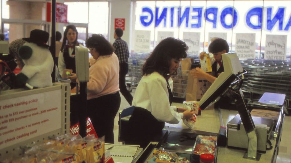 Woman checks out with grocery cashier