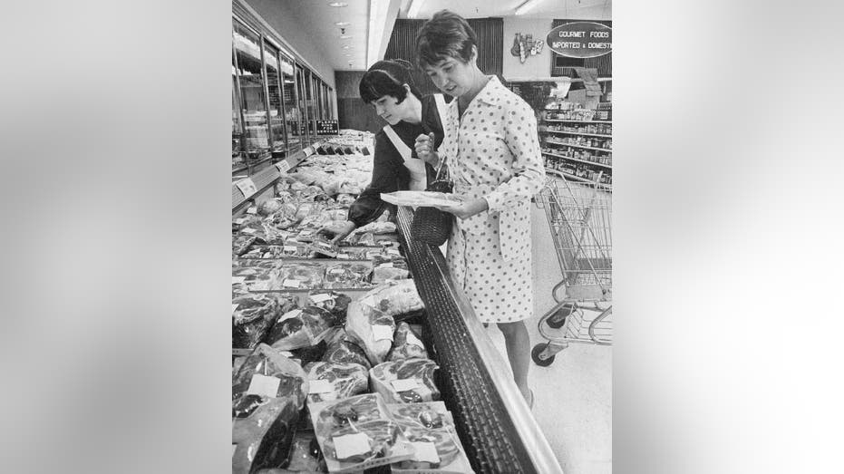 Two women shop for groceries in meat aisle