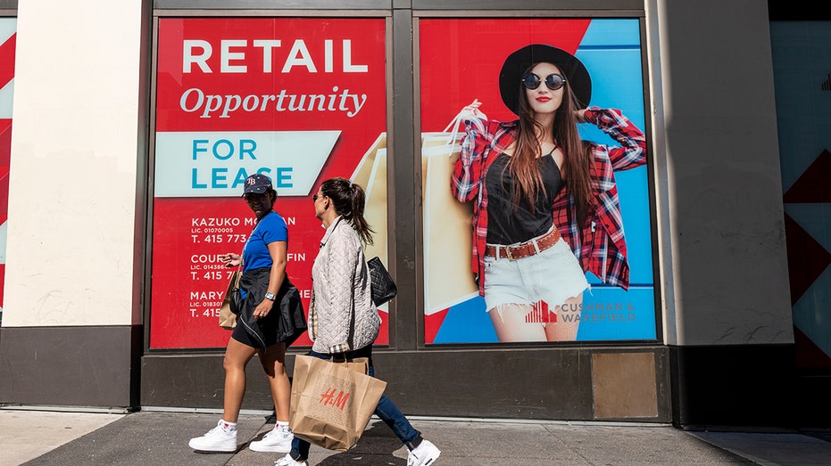 Shoppers walk past commercial building space