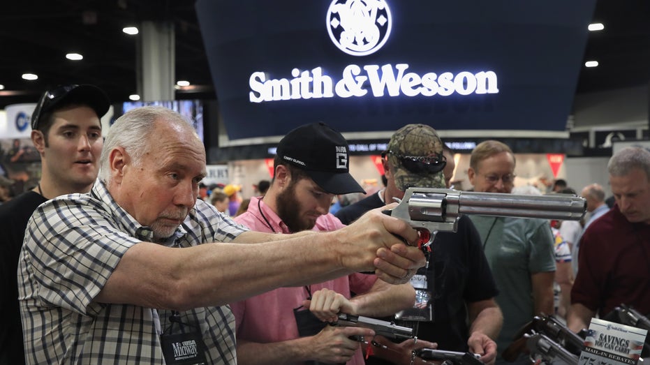 Membro da NRA segurando a pistola Smith & Wesson