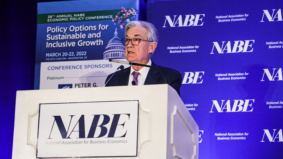 Jerome Powell speaking behind a podium at a NABE conference