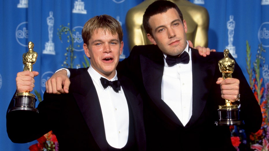 Matt Damon and Ben Affleck holding Oscars for "Good Will Hunting"