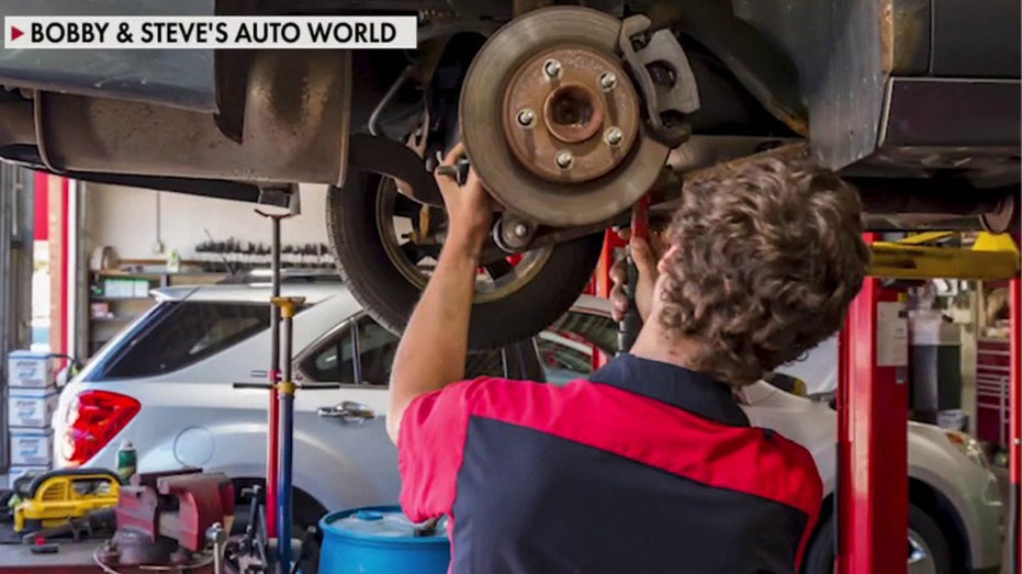 mechanic works on car