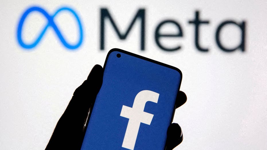A Meta logo with a phone containing a facebook logo in front