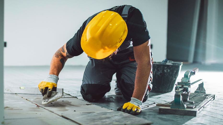 Contractor adds tiles to floor