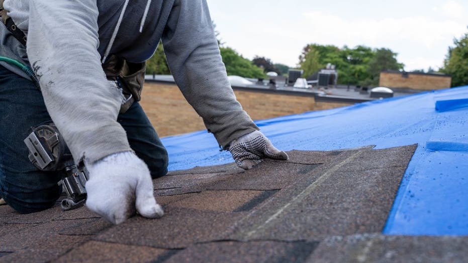 Person installs new roof tiles
