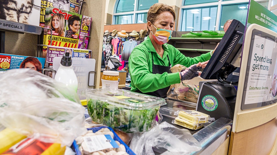 A cashier rings up a customer at a grocery store