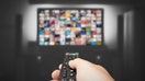 Video on demand, TV streaming, multimedia. Hand holding remote control