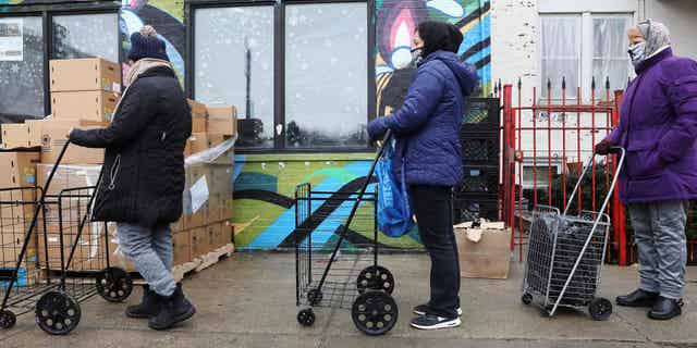 People wait for food in the food pantry at the New Life Center in Chicago, Illinois, March 16, 2021. As the coronavirus exacerbated public health problems in the United States.