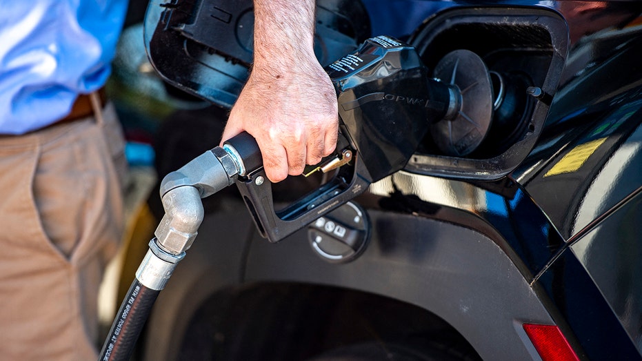 A gas pump fueling a car