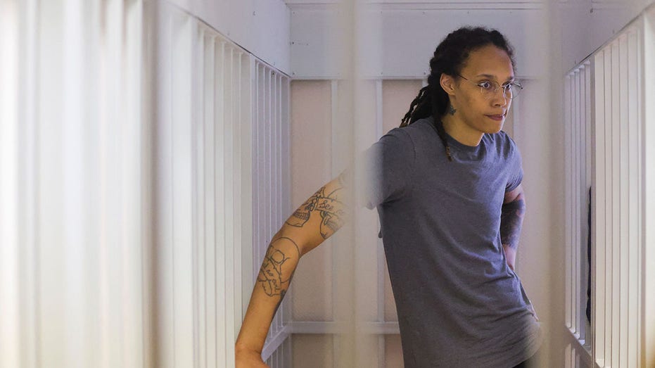 Brittney Griner sits in a Russian defendants'cage