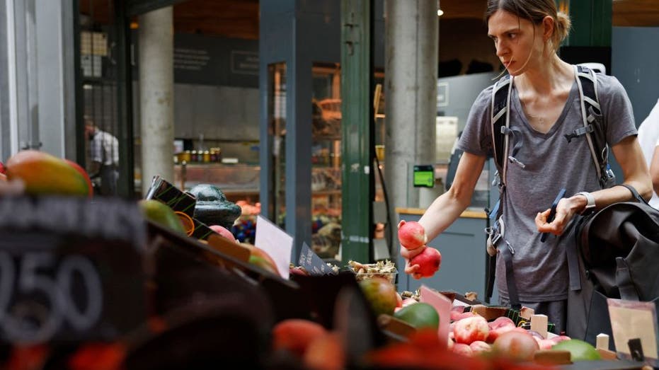 A woman buys fruit