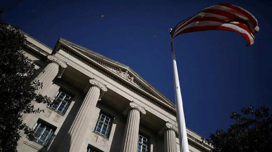 Department of Justice building in Washington DC with an American flag in front of it