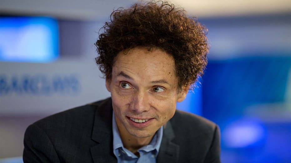 Author Malcolm Gladwell wearing a suit during an interview