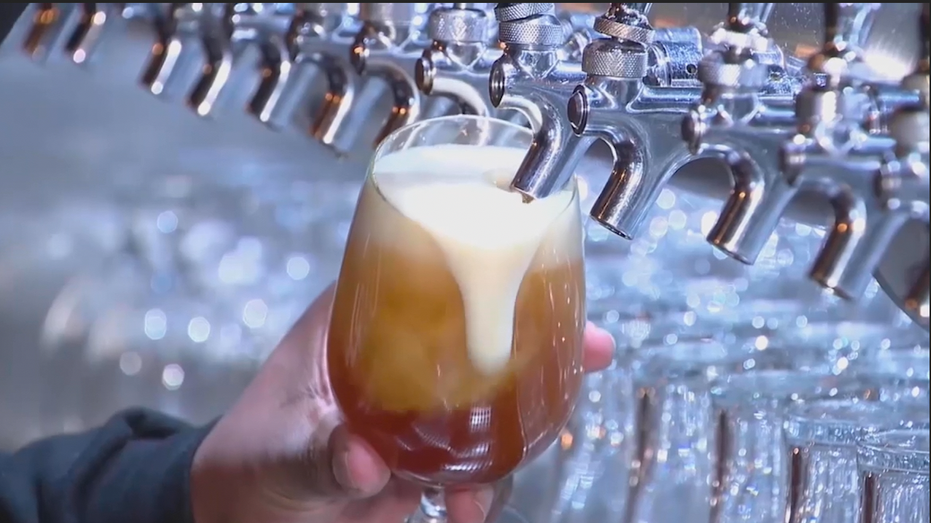 Hand holding glass under beer tap as beer flows into the glass