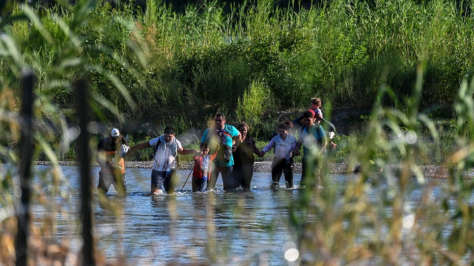Migrants crossing border in water