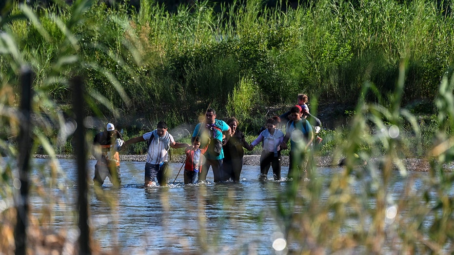 Migrants crossing border in water