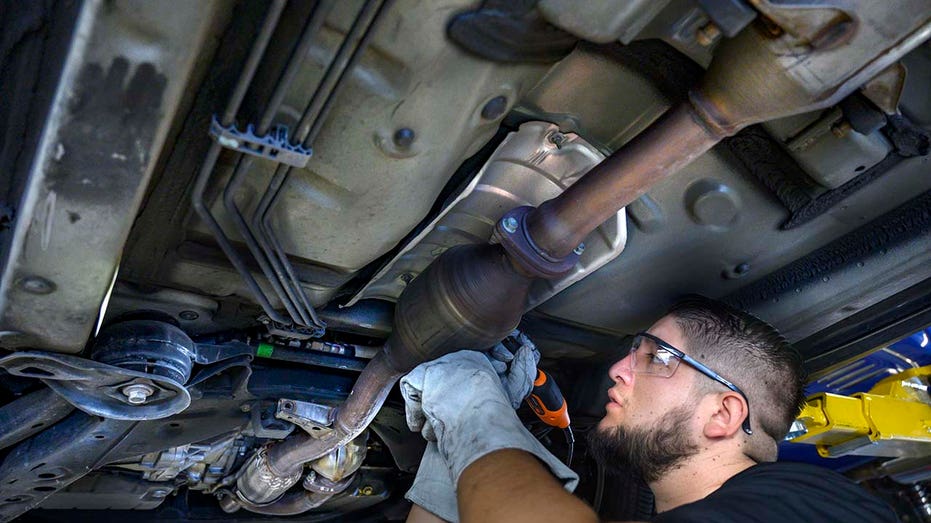 utomotive technician works on a catalytic converter