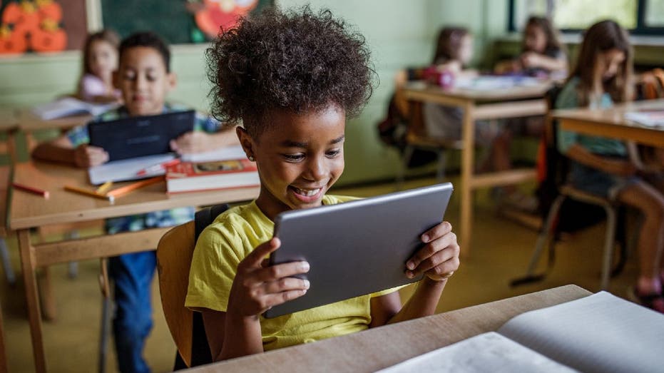 students hold tablets in school